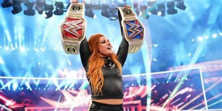 Becky Lynch holding two title belts