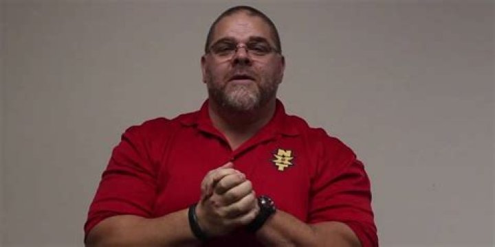 Bill DeMott wearing a red NXT shirt